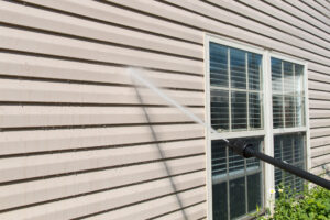 Pressure washing home siding to remove dirt and grime, ensuring a clean and well-maintained exterior.