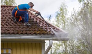 man on roof servicing a gutter