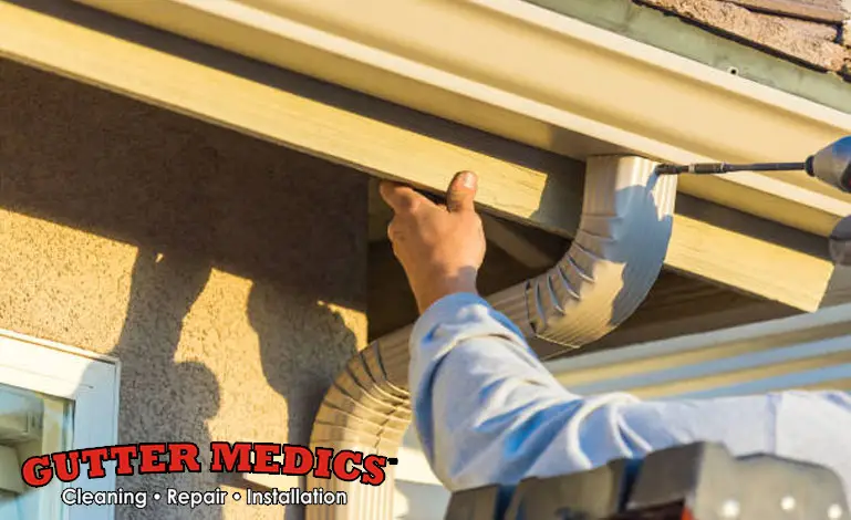 man repairing the roof gutter