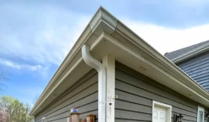 Clean seamless gutters installed on a suburban home showing protection from fall water and roof damage.