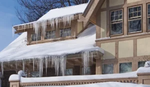 Icicles hanging from roof gutters show winter gutter emergencies caused by ice dam buildup.