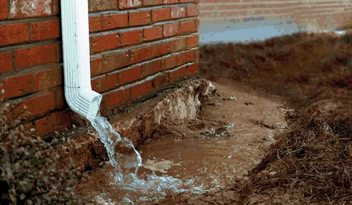 Downspout Services in Naperville, IL Water flowing from a downspout near brick foundation, indicating poor drainage and need for downspout services.